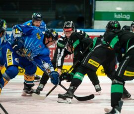 Hokejisti HK Olimpija in VSV Beljak v boju za plošček ob ogradi.